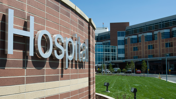 Hospital sign outside of a hospital on a sunny day.